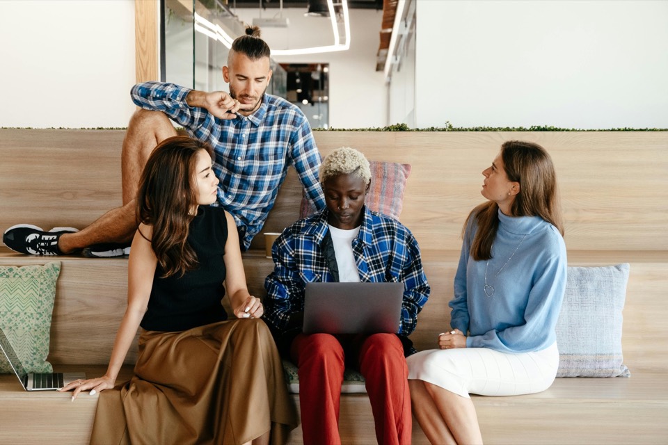 Diverse team reviewing work together with a laptop