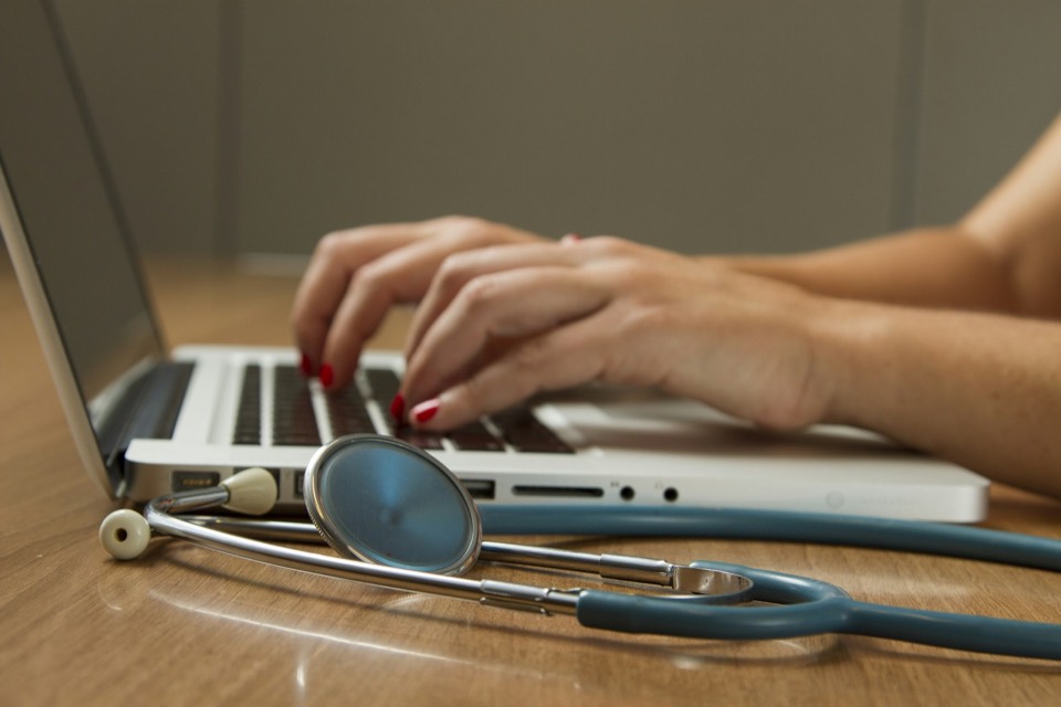 Stethoscope and laptop on a private-practice desk