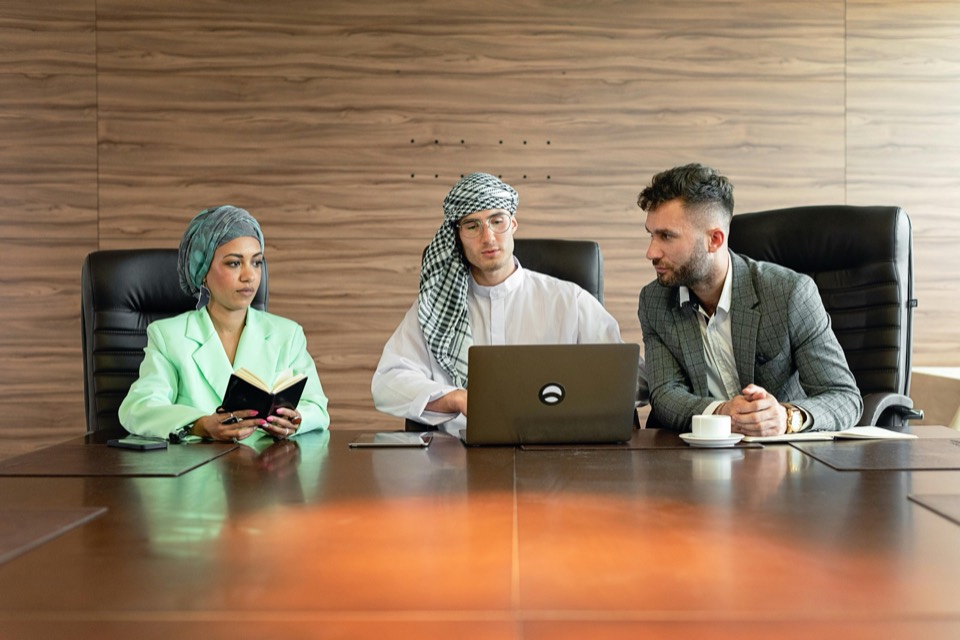 Multicultural team reviewing a business plan around a laptop