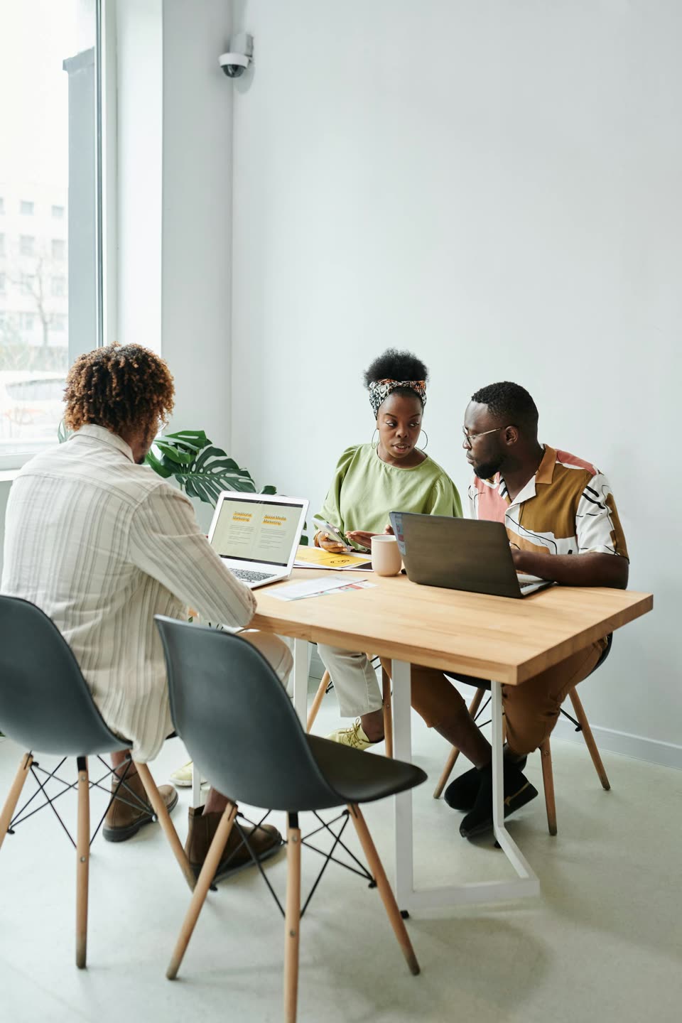 Professional team reviewing growth priorities around a laptop