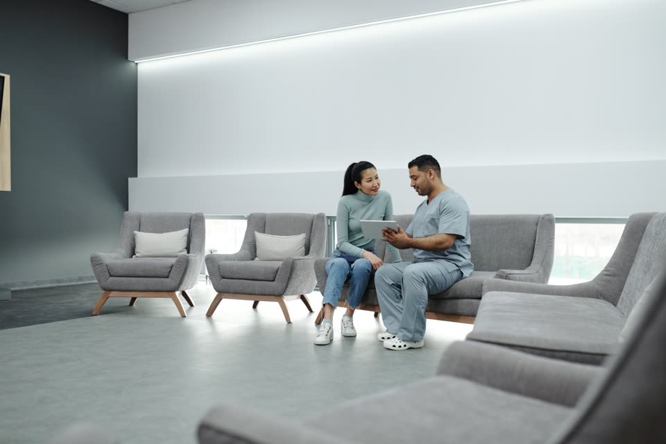 Doctor using a tablet while consulting with a patient