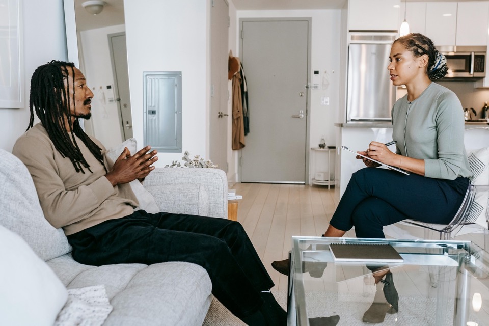 Therapist taking notes while consulting with a patient